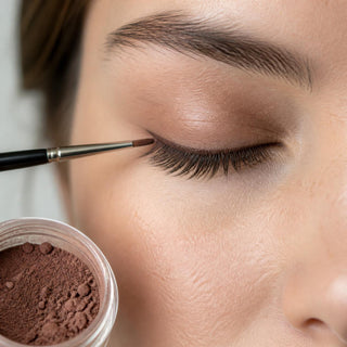 Fine liner brush applying mineral pigment along the lash line