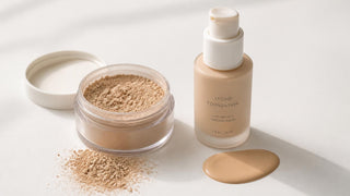 Open jar of loose mineral powder foundation next to a bottle of liquid foundation on a white surface