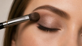 Makeup brush blending loose mineral eyeshadow on the eyelid and crease